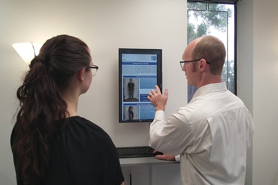 Dr. Jason reviewing a digital posture report with a practice member